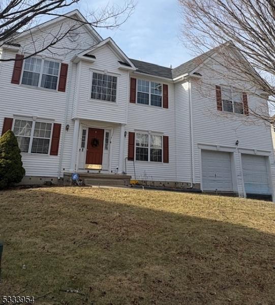 view of front of home with a garage and a front lawn