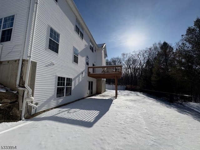 snow covered rear of property featuring a wooden deck