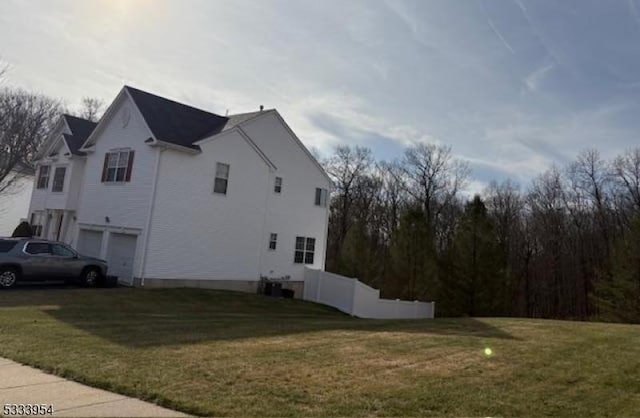 view of side of home with a garage and a lawn