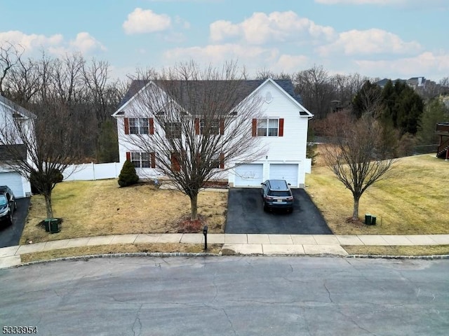 view of front of house featuring driveway, an attached garage, and a front yard