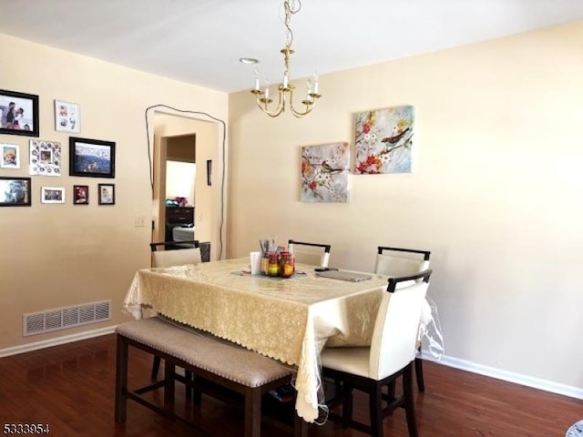 dining area featuring a chandelier, dark wood-type flooring, visible vents, and baseboards