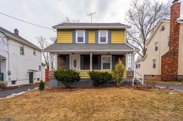 view of front facade with a front yard and covered porch