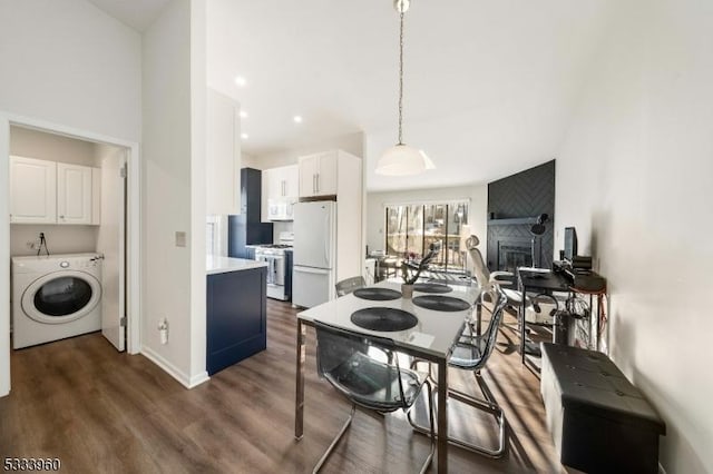 kitchen featuring dark hardwood / wood-style floors, pendant lighting, washer / clothes dryer, white cabinetry, and white appliances