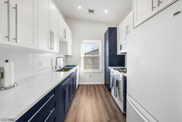 kitchen featuring white appliances, sink, and white cabinets