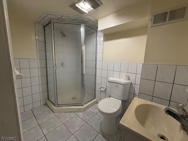 bathroom featuring tile walls, vanity, walk in shower, toilet, and tile patterned floors