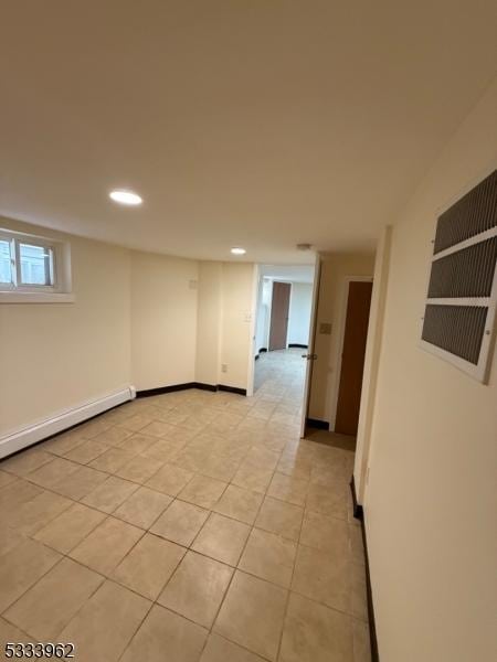 tiled spare room with baseboard heating