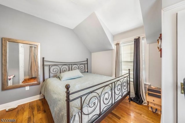 bedroom with lofted ceiling and hardwood / wood-style floors