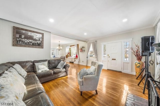 living room featuring crown molding, hardwood / wood-style floors, and a chandelier