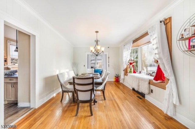 dining space with crown molding and light wood-type flooring