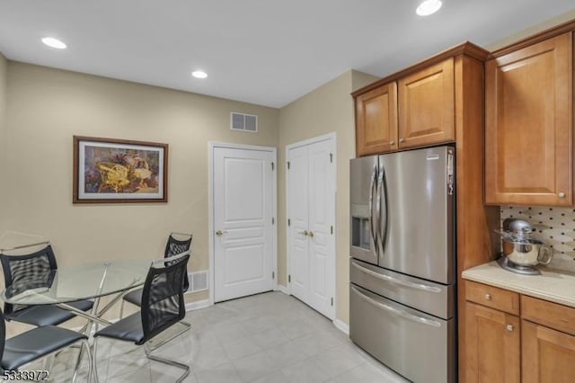 kitchen featuring stainless steel fridge and decorative backsplash