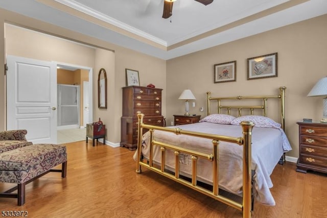 bedroom with hardwood / wood-style floors, ornamental molding, a raised ceiling, and ceiling fan