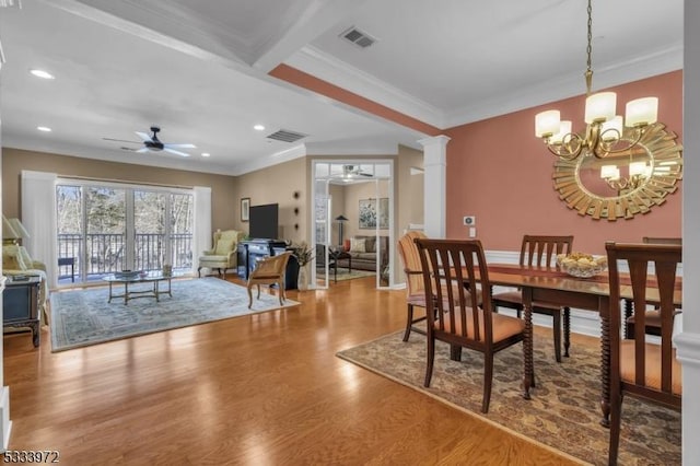 dining room with ceiling fan with notable chandelier, ornamental molding, and ornate columns