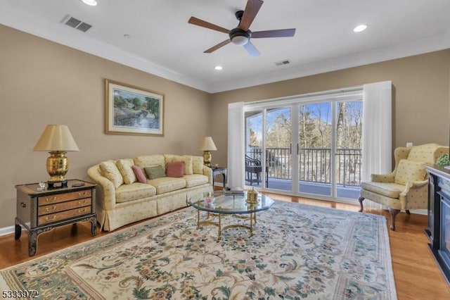 living room featuring crown molding, ceiling fan, and hardwood / wood-style floors