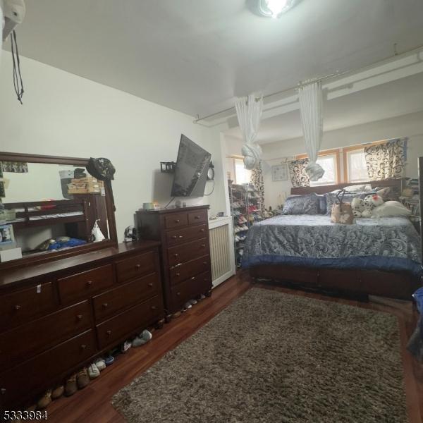 bedroom with dark wood-type flooring