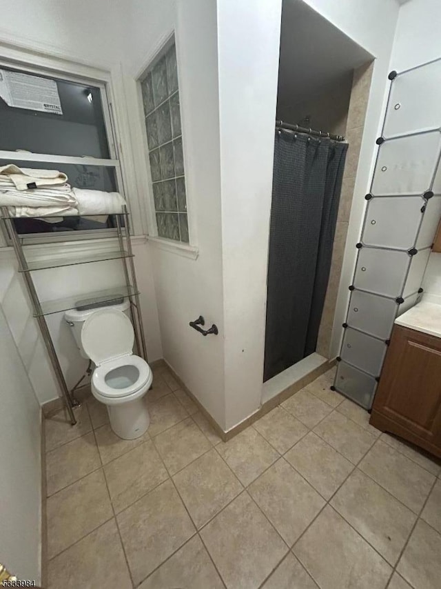 bathroom featuring tile patterned flooring, vanity, curtained shower, and toilet