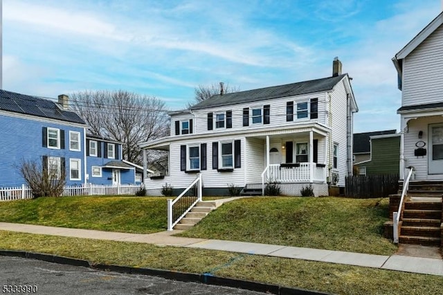 view of front of property featuring covered porch and a front lawn