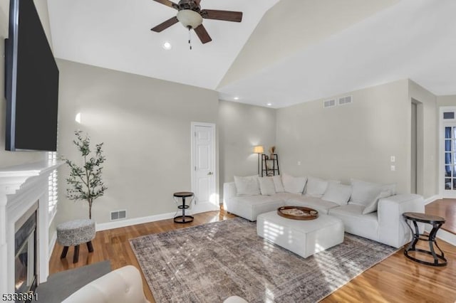 living room with hardwood / wood-style flooring, ceiling fan, and lofted ceiling