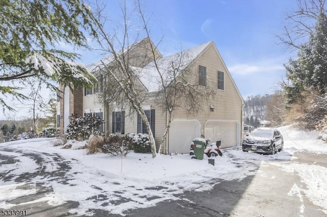 view of snowy exterior featuring a garage