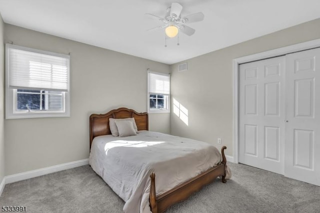 bedroom with ceiling fan, light colored carpet, and a closet