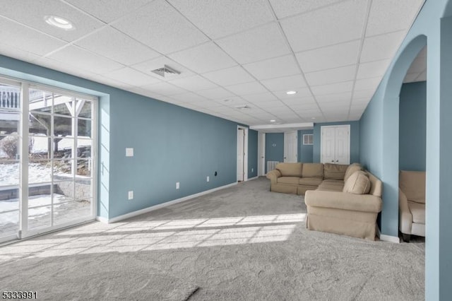 living room featuring a drop ceiling and light colored carpet