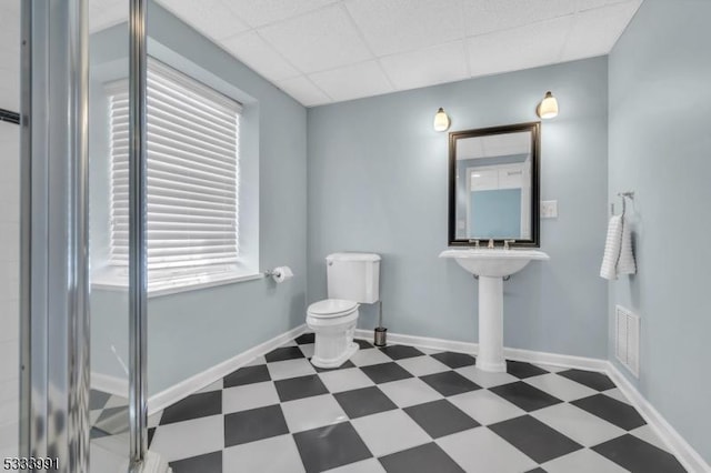 bathroom with a paneled ceiling and toilet