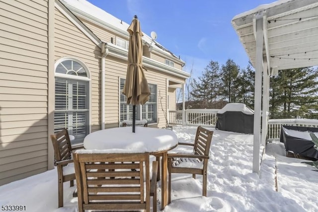 snow covered deck with a grill