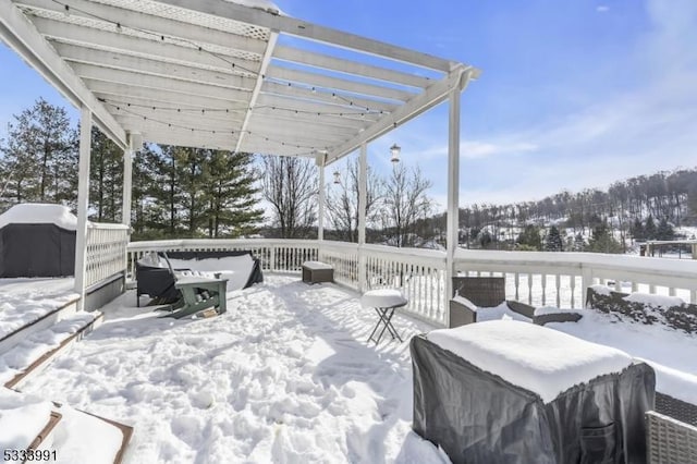 snow covered deck featuring a pergola