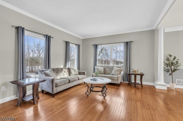 living room featuring crown molding, decorative columns, and hardwood / wood-style floors