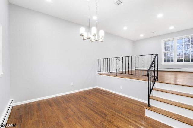 interior space featuring hardwood / wood-style flooring, a baseboard heating unit, and an inviting chandelier