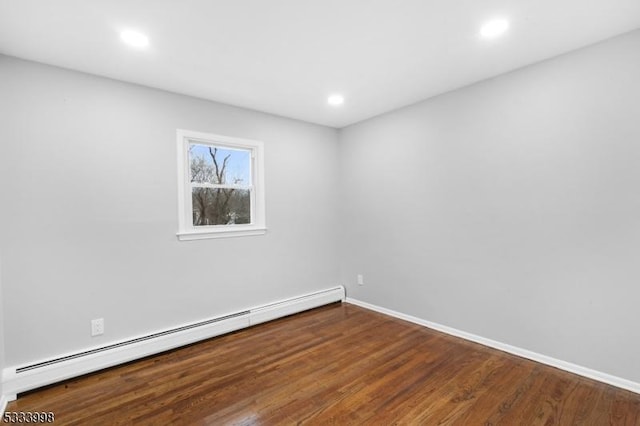 unfurnished room featuring a baseboard radiator and hardwood / wood-style floors