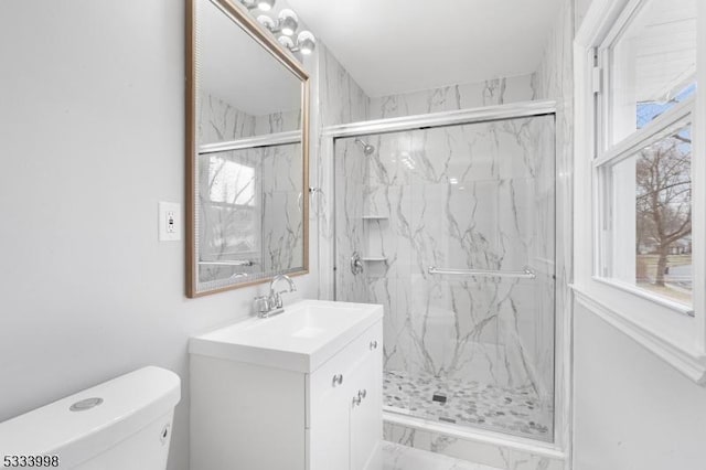 bathroom featuring vanity, toilet, and a shower with door