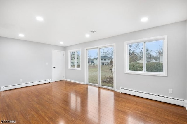 empty room featuring a baseboard radiator and hardwood / wood-style floors