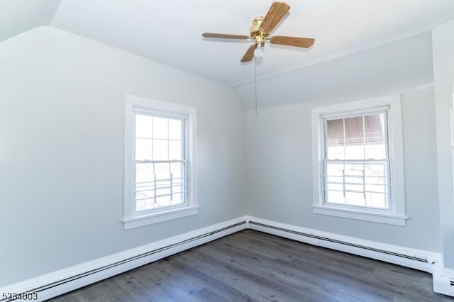 empty room with ceiling fan, dark wood-type flooring, a baseboard heating unit, and vaulted ceiling