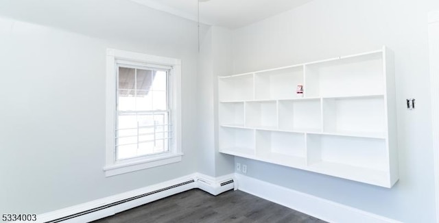 empty room with a baseboard radiator and dark wood-type flooring