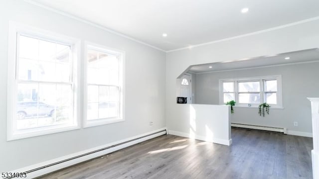 unfurnished room featuring baseboard heating, dark hardwood / wood-style floors, and ornamental molding