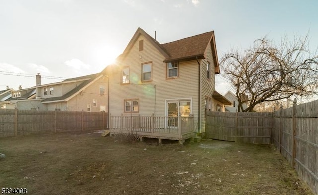 back of house with a lawn and a wooden deck