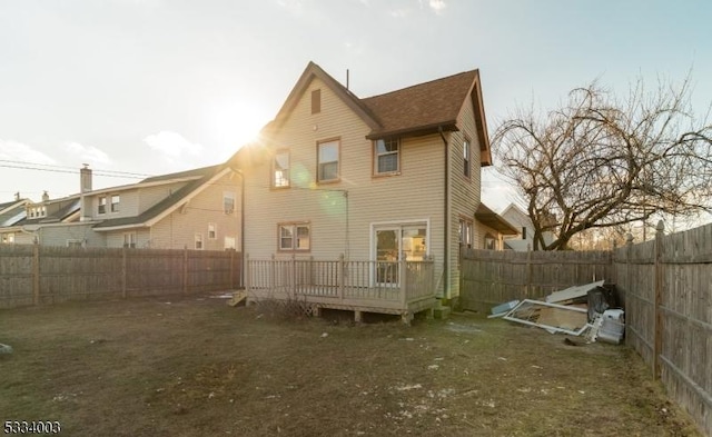 back of house with a deck and a lawn