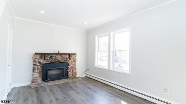 unfurnished living room featuring baseboard heating, hardwood / wood-style floors, crown molding, and a stone fireplace