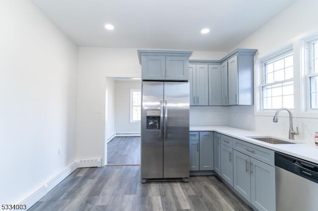 kitchen featuring dark wood-type flooring, sink, appliances with stainless steel finishes, and tasteful backsplash