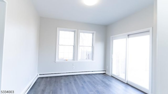 empty room with a baseboard radiator and light wood-type flooring