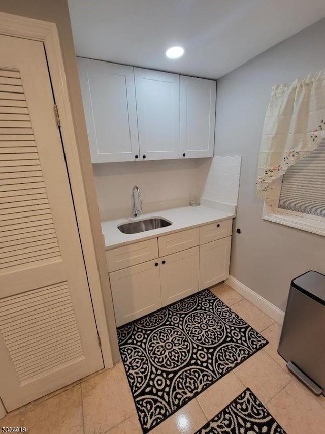 interior space with sink, white cabinetry, and light tile patterned floors