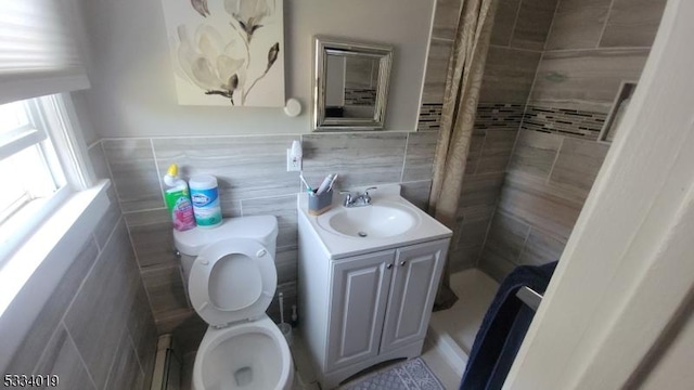 bathroom with toilet, tile walls, and vanity