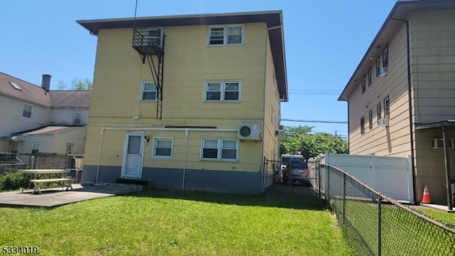 back of house with a patio area and a yard