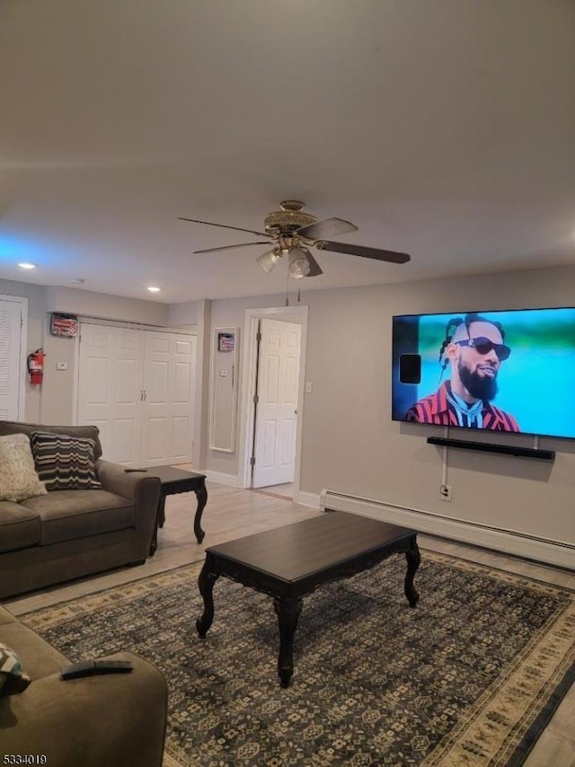 living room with ceiling fan, baseboard heating, and light hardwood / wood-style flooring