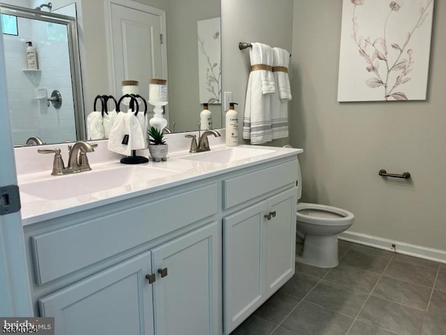 bathroom featuring vanity, a shower with shower door, and toilet