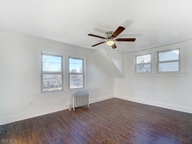 additional living space with ceiling fan, dark wood-type flooring, and radiator