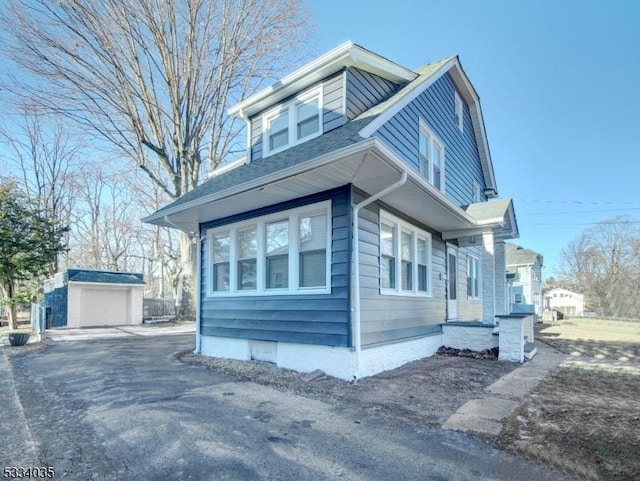 view of side of home featuring a garage and an outdoor structure