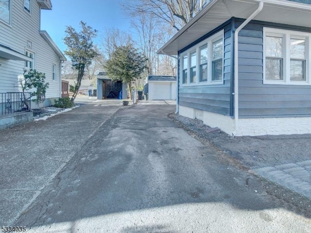 view of property exterior featuring a garage and an outdoor structure