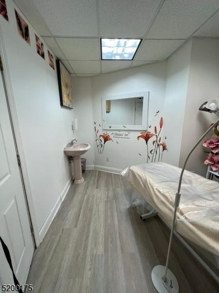 bathroom with hardwood / wood-style flooring and a paneled ceiling