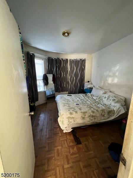 bedroom with dark parquet flooring